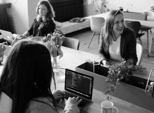 People collaborating at a table with laptops